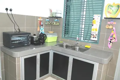 a kitchen with a sink and a microwave at Qstay Sitiawan Townhouse (Minnie Dreams) - \u7c73\u59ae\u68a6 in Sitiawan