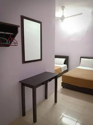 a room with two beds and a table and a mirror at Mag Homestay at Crown Imperial Court, Brinchang in Cameron Highlands
