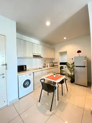 a kitchen with a table and a refrigerator at Mansion One by Sky Hive in George Town