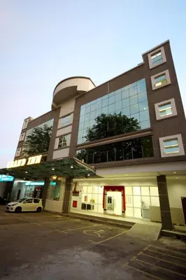 a building with a car parked in a parking lot at Grand Inn Hotel - Macalister Road in George Town