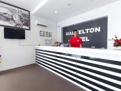 a man standing behind a counter in a room at Hotel O Marvelton Hotel in Butterworth