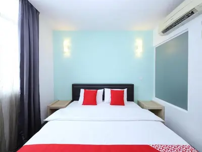 a bedroom with a large bed with red pillows at Hotel O Marvelton Hotel in Butterworth
