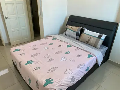 a bed with a pink comforter on top of it at Spice Tunas 3B2B House in Bayan Lepas