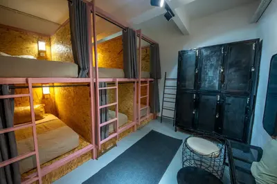a room with three bunk beds and a mirror at The Brownstone Hostel & Space in Ipoh
