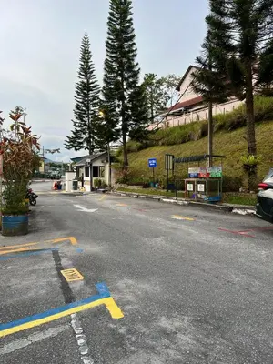 a parking lot with a yellow arrow on a street at D'Puncak Arabella Muslim Homestay in Cameron Highlands