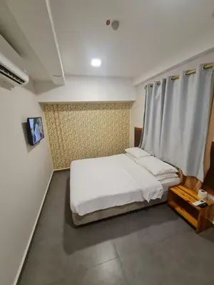 a bedroom with a white bed and a window at Hotel Bestari in Kuala Lipis