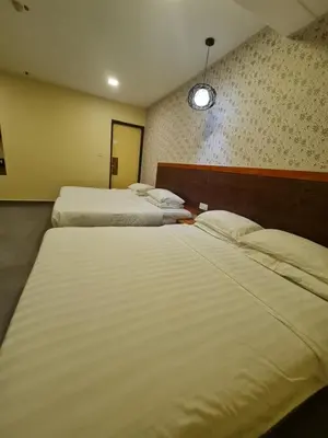 a hotel room with two beds and a mirror at Hotel Bestari in Kuala Lipis