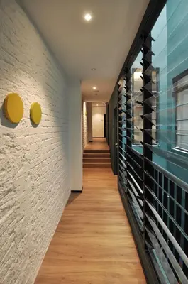 a hallway with a brick wall and wooden floors at Kooning in George Town