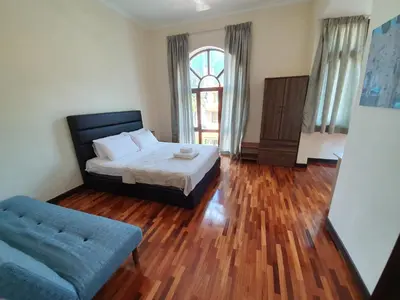 a bedroom with a bed and a blue couch at Eden Cosy Living in Batu Ferringhi