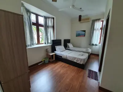 a bedroom with a bed in a room with wooden floors at Eden Cosy Living in Batu Ferringhi