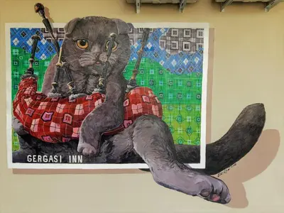 a painting of a cat sitting on a wall at Gergasi Inn in Ipoh