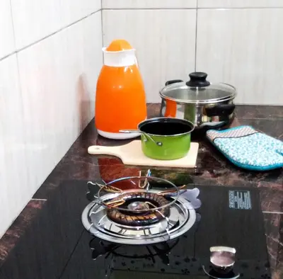 a kitchen counter with a stove with a pot on it at Rumah Tamu Azizah in Kampong Tanjong Bayan