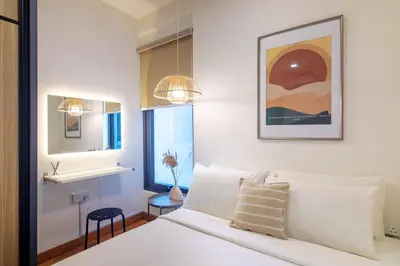 a bedroom with a white bed and a mirror at Tropicana 218 X Airlevate Suites in George Town