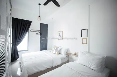 two beds in a room with white walls at Xandra's 218 Macalister Suite in George Town