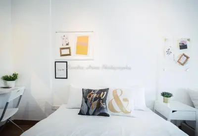 a bedroom with white walls and a white bed at Xandra's 218 Macalister Suite in George Town