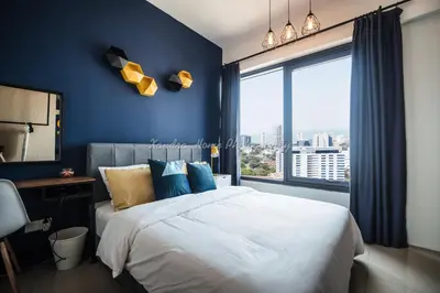 a bedroom with a bed with blue walls and a window at Xandra's 218 Macalister Suite in George Town