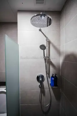 a shower with a shower head in a bathroom at Xandra's 218 Macalister Suite in George Town