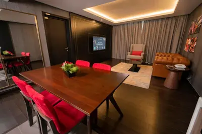 a dining room with a wooden table and red chairs at Jazz Hotel Penang in George Town