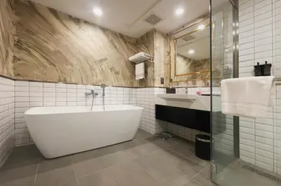 a bathroom with a tub and a sink at Jazz Hotel Penang in George Town