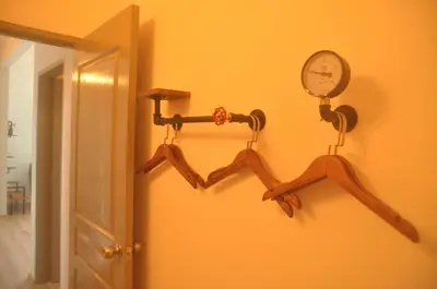 a room with two hangers and a clock on a wall at Plumber house in Tanah Rata