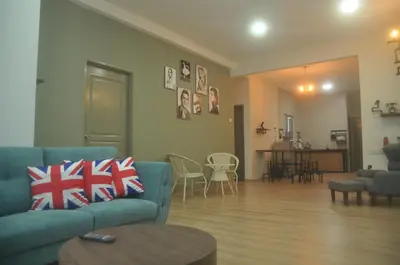 a living room with a blue couch and a table at Plumber house in Tanah Rata