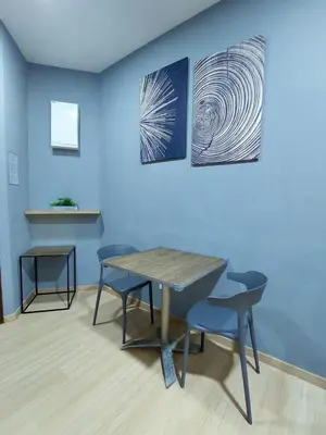 a table and two chairs in front of a blue wall at 118 Island Plaza Suite City8 by Joal in Tanjong Tokong