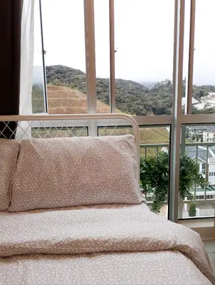 a bed in front of a window with a view at Penthouse - Secret Garden de Cameron, Night Market in Tanah Rata