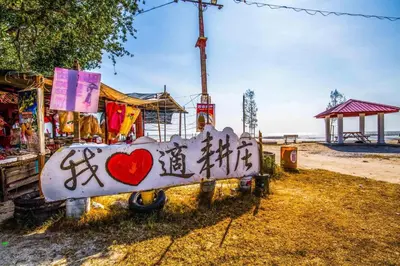 a sign with graffiti on it next to the beach at One Residence Sekinchan \u9002\u8015\u5e84\u65e0\u654c\u6d77\u666f in Sekincan