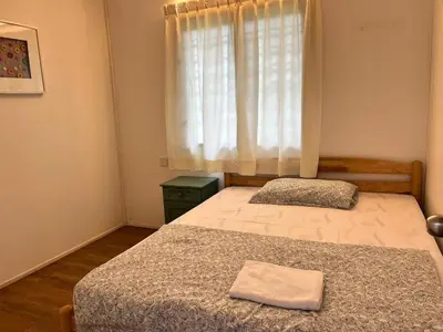 two beds in a small bedroom with a window at Moonriver Lodge in Cameron Highlands