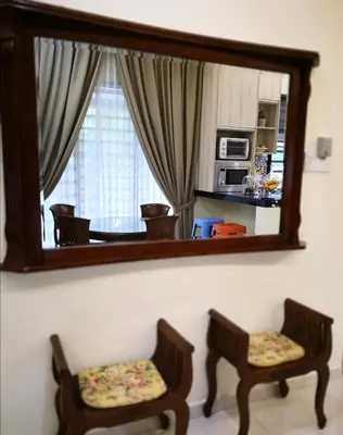 a mirror on a wall with two chairs in a room at Rumah Citta Homestay Tambun Ipoh in Ipoh