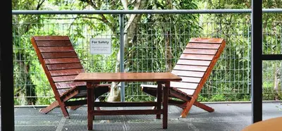 a bench and a table and a chair on a balcony at Boulder Valley in Batu Ferringhi