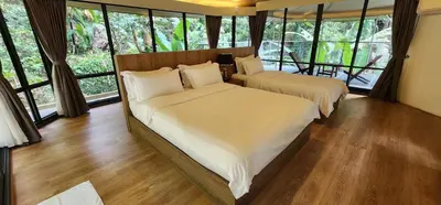 two beds in a room with large windows at Boulder Valley in Batu Ferringhi