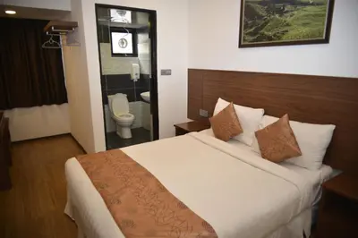 a bedroom with a bed and a bathroom with a toilet at Highlanders Hotel in Cameron Highlands