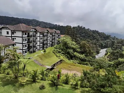 an apartment building on a hill with a river at Cameron Greenhill Apartment in Cameron Highlands
