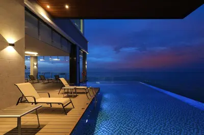 a balcony with a swimming pool at night at Hompton Hotel by the Beach in George Town