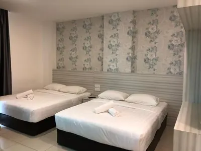 two beds in a hotel room with white pillows at KU-3 HOTEL in Tapah