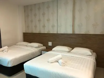 a hotel room with two beds with white sheets at KU-3 HOTEL in Tapah