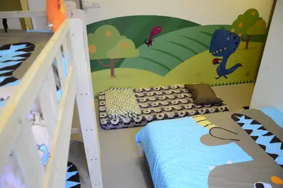 a childs bedroom with a dinosaur mural on the wall at The Woodz Thematic Homestay - Cameron Highlands Golden Hills Night Market in Cameron Highlands