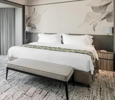 a bedroom with a large bed and a bench at Ascott Gurney Penang in George Town