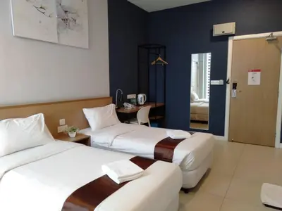 a hotel room with two beds and a desk at MD Boutique Hotel in Kampar