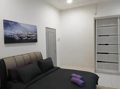 a bedroom with a bed with a purple stuffed animal on it at Dudu Guesthouse Kuala Kangsar in Kuala Kangsar