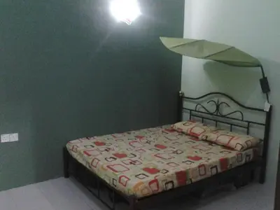 a bed in a room with a light above it at GERIK BANDING HOMESTAY in Gerik