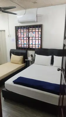 a bedroom with two beds in a room at JSW Inn in Gelugor