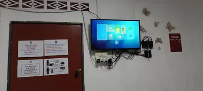 a flat screen tv on a wall next to a door at JSW Inn in Gelugor