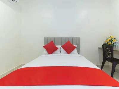 a bedroom with a red and white bed with a chair at Hotel Agro in Raub