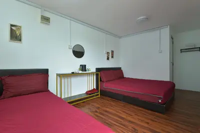 a bedroom with two beds with red sheets at AsiaCamp - Chalet Sungai Sireh in Tanjung Karang