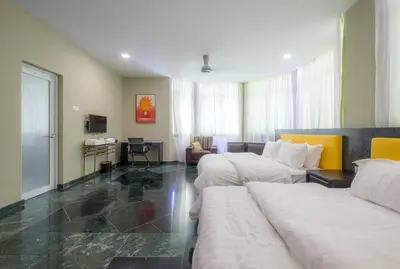 a hotel room with two beds and a couch at 6, Persiaran Tanjung Bunga 3 in Batu Ferringhi