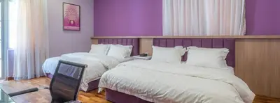 a bedroom with two beds and a purple wall at 6, Persiaran Tanjung Bunga 3 in Batu Ferringhi