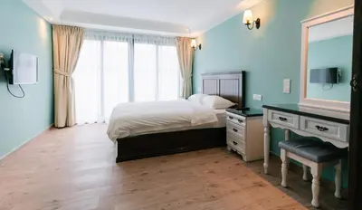 a bedroom with a bed and a dresser and a mirror at The Tudor in Ipoh