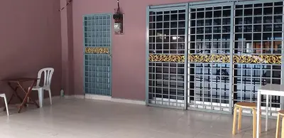 a wine cellar with glass doors and tables and chairs at AsSalam Homestay in Seri Iskandar